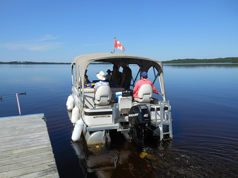 A pontoon cruise sets sail on Kenogamissi Lake in Canada's boreal forest